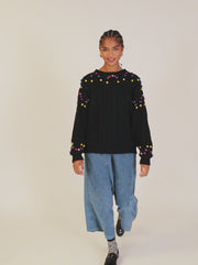 MAGLIONE CON POMPON E TRECCIA NERA