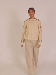 Maglione con pompon intrecciato color crema